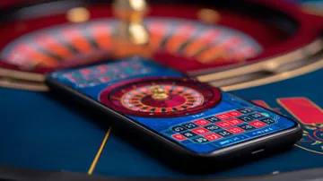 A man celebrating a winning moment on his laptop while gaming symbols float around him, capturing the excitement of 10WIM games.